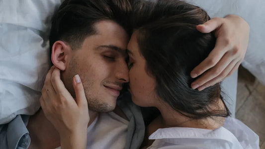 Intimate couple embracing in bed, sharing a tender moment in white bedding