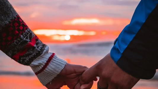 Couple holding hands at sunset, romantic beach moment